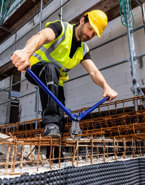 Construction site worker cuts mesh mat with TECWERK bolt cutters
