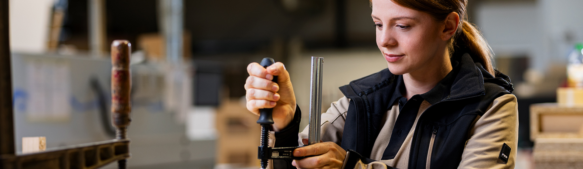 Handwerkerin befestigt Schraubzwingen am Werkstück