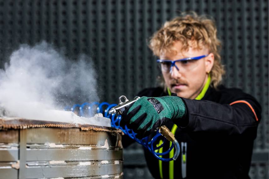 Tecwerk Model beim reinigen eines Werkstücks mit einer Drucklufpistole