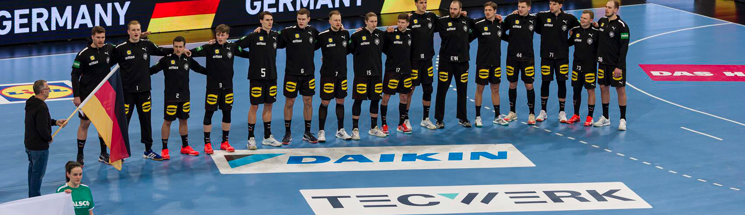 Gesamtes Deutsches DHB Handball Team steht am Mittelkreis mit TECWERK Werbung