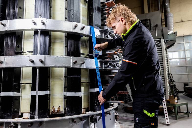 Arbeiter sichert Ladung mit Zugurt