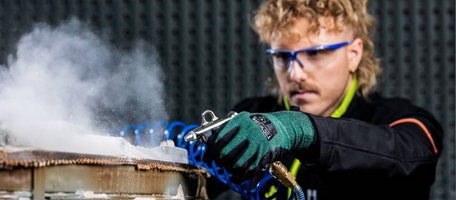 Tecwerk Model beim reinigen eines Werkstücks mit einer Drucklufpistole